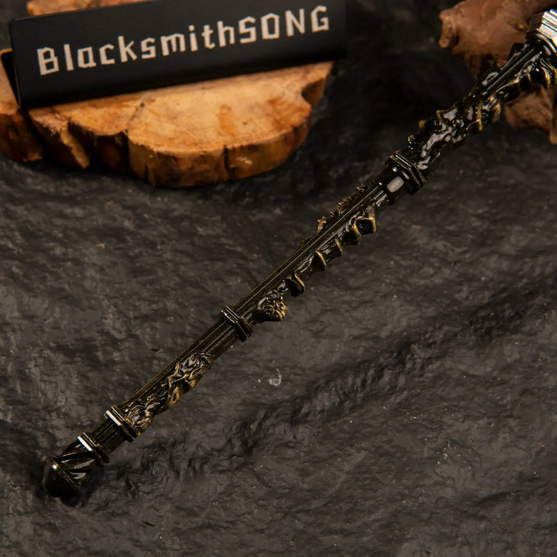 Close-up detail of the textured handle and antique gold crossguard of the Mohgwyn's Sacred Spear metal miniature weapon.
