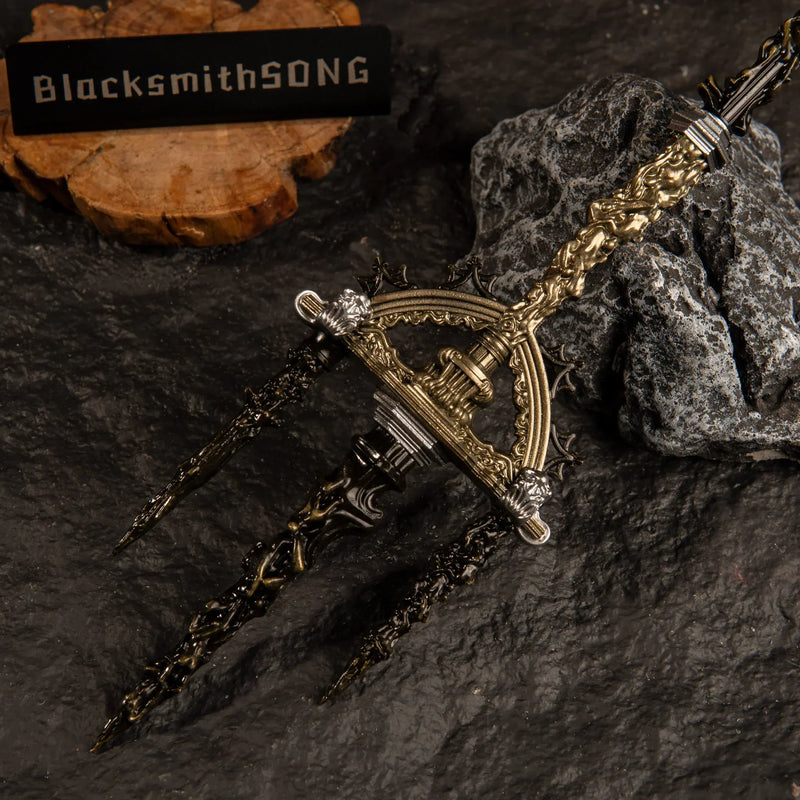 Macro close-up shot of the three-pronged trident head of the Mohgwyn's Sacred Spear replica, highlighting the detailed golden filigree and black finish.