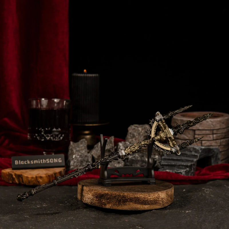 Mohgwyn's Sacred Spear miniature weapon placed on a small horizontal wooden stand with blurred black candles and red velvet in the background.