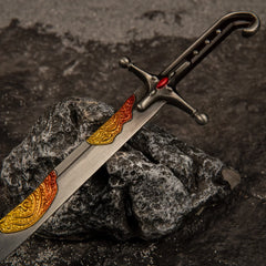 Macro close-up shot of the dark handle, crossguard with a red gem, and the lower blade of the Nomad's Kilij metal miniature.