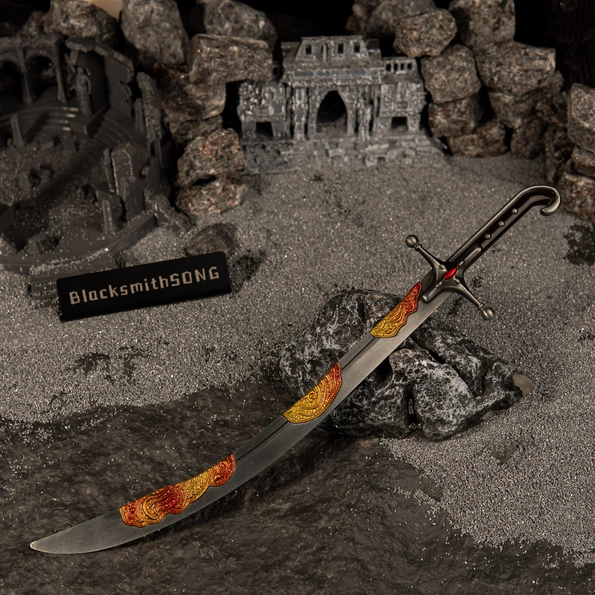 Wide angle view of the Nomad's Kilij metal miniature lying diagonally across dark rocks in a ruined temple setting with a BlacksmithSONG sign.
