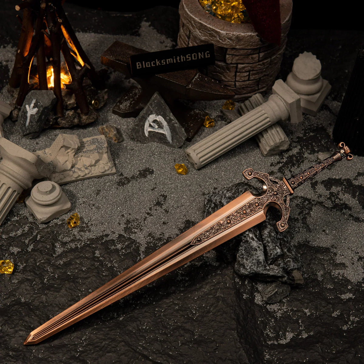 Ordovis's Greatsword metal replica resting on dark rocks, surrounded by grey sand, broken classical pillars, rune stones, and a miniature bonfire.