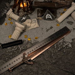 Ordovis's Greatsword metal replica placed next to a measuring ruler on grey sand, confirming a total length of approximately 30 centimeters.