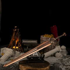 Ordovis's Greatsword miniature resting horizontally on a small black stand, positioned on a wooden base with a lit bonfire in the background.