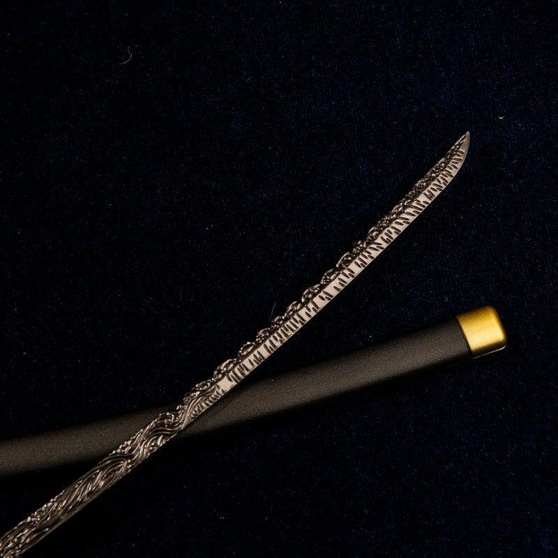 Detailed view of the metallic blade of the Star Shadow miniature sword, showcasing swirling, Damascus-style patterns.