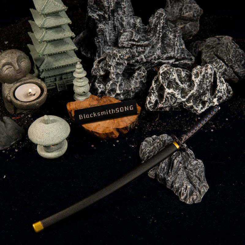 Angled overhead view of the Star Shadow katana replica in a dark, peaceful miniature rock garden setting with lit candles.