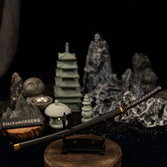Slightly angled view of the Star Shadow katana on a small display stand within a miniature stone garden diorama.