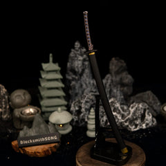 Vertical display of the Star Shadow katana replica on an upright black stand, set against a dark background with miniature stone statues.