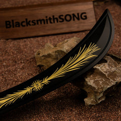Detailed close-up view of the matte black curved blade of the Starscourge Greatsword miniature, featuring the iconic golden gravity crest pattern.