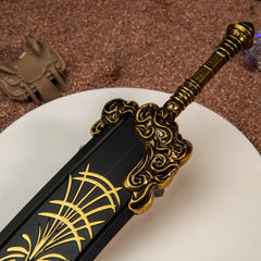Close-up of the Starscourge Greatsword metal miniature's hilt, highlighting the engraved gold filigree patterns.