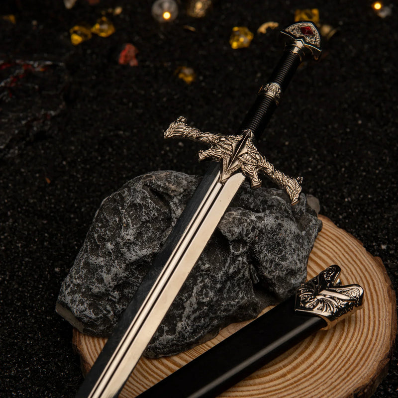 Blackfyre replica — dragon crossguard and scaled collar detail, resting on stone.
