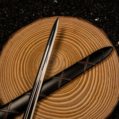 Dawn Sword replica — full blade with its cast fullers, shown beside the black cross-laced scabbard.