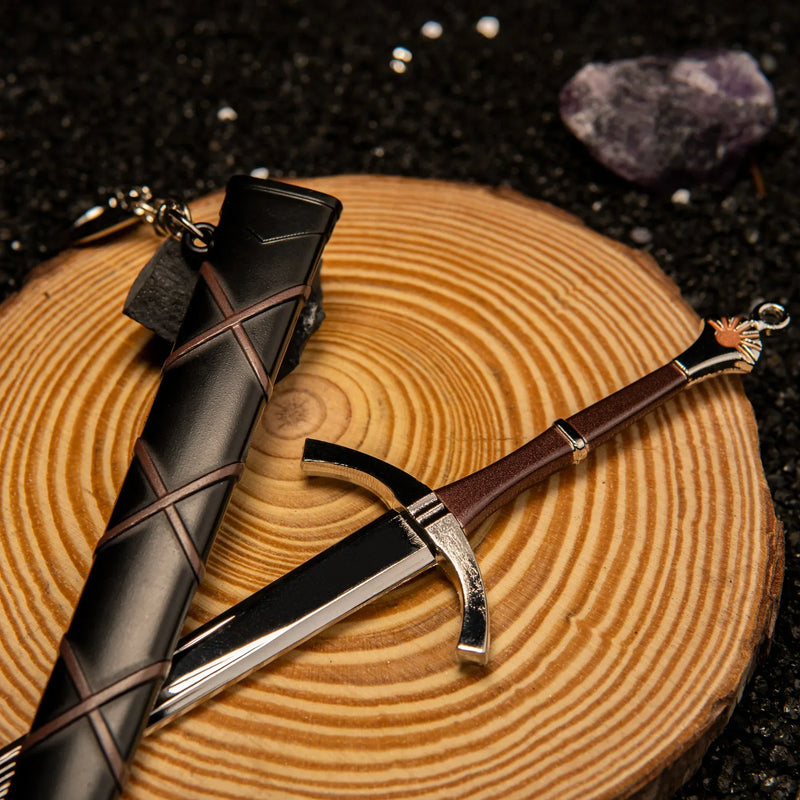 Dawn Sword replica — swept crossguard and dark red grip on a wood slice, scabbard laid alongside.