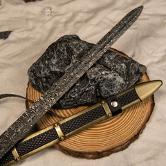 Longclaw replica — rippled blade figuring laid across a wood round.