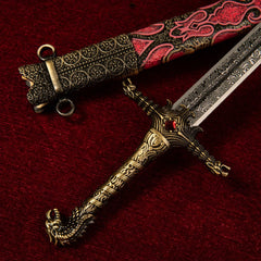 Oathkeeper replica — gold crossguard and hilt detail on red cloth.
