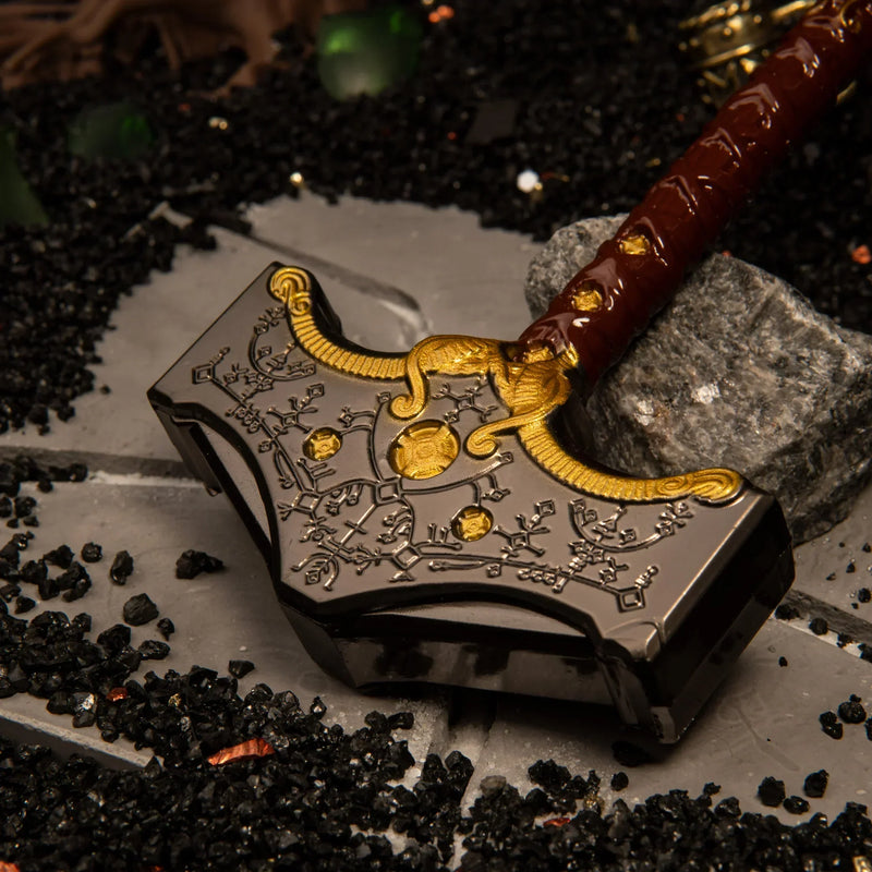 Mjolnir replica — hammer head close-up showing the rune engraving and gold studs.