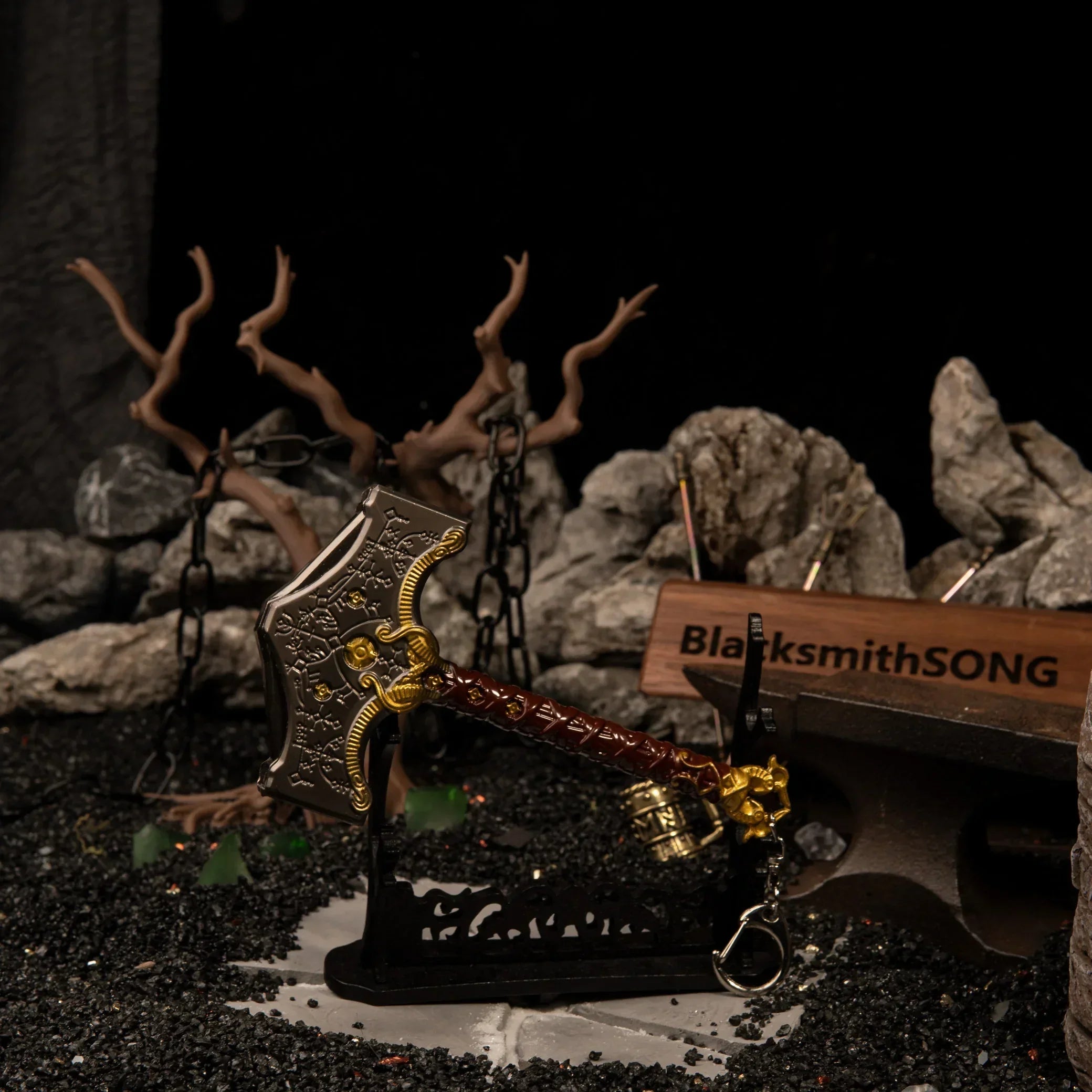 Mjolnir metal replica displayed horizontally on a black stand in a dark rocky forest diorama.