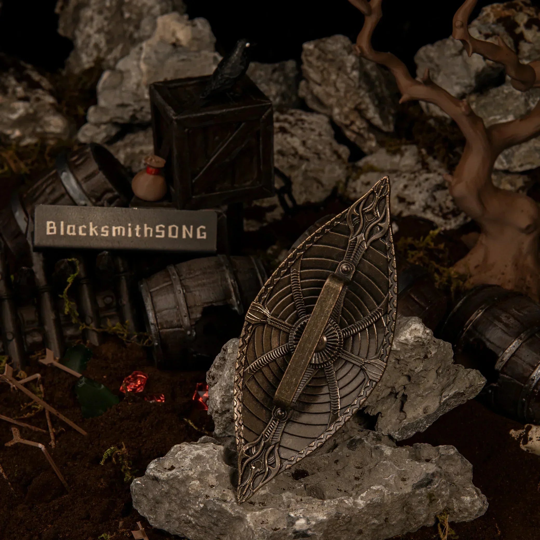 The back side of the Dauntless Shield metal replica showing a black grip handle detail resting on rocks.