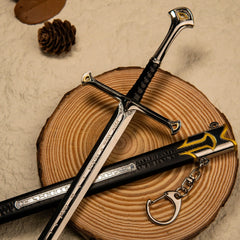 Andúril replica — swept crossguard, gold-accented pommel and ribbed grip on a wood slice.