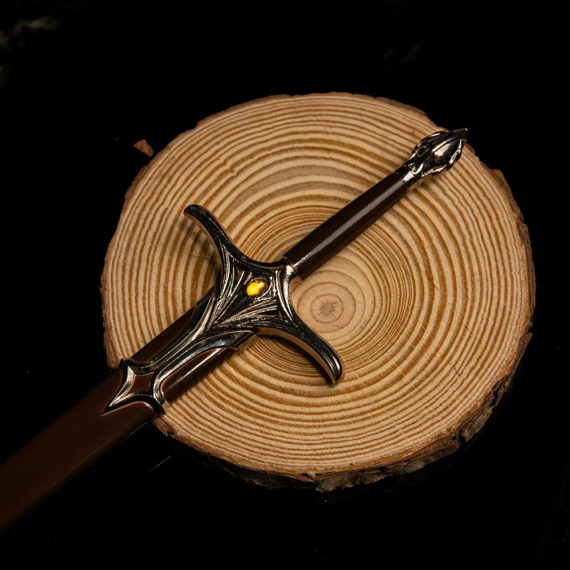 Galadriel Sword replica — winged crossguard with amber-toned inset stone, on a wood slice.