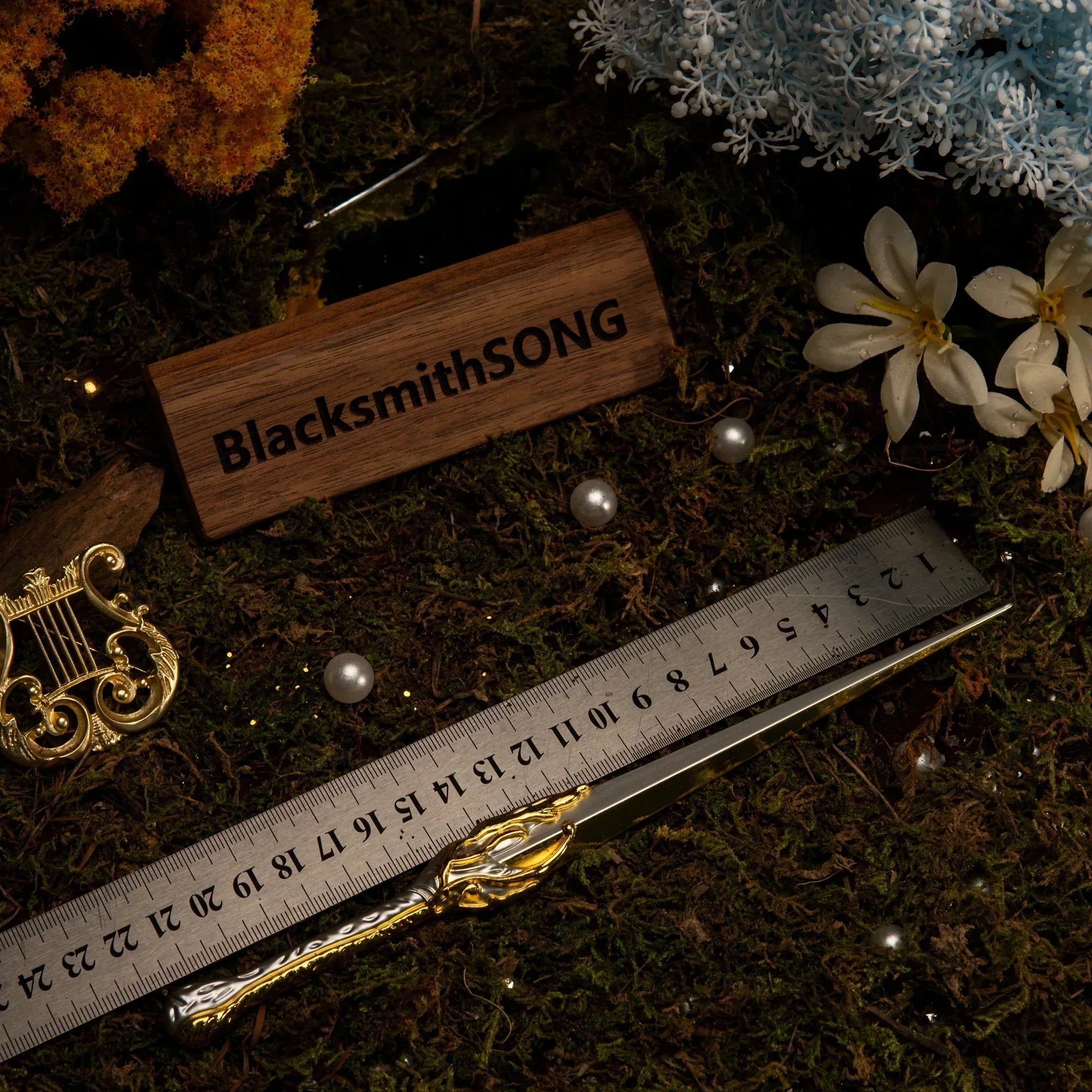 Metal ruler measuring the Galadriel's Dagger replica, confirming its 22cm length on the mossy background.