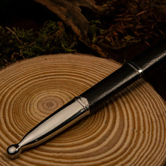 Ranger Sword replica — blade tip close-up on a wood slice.