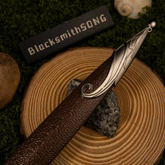 Sting replica — blade fuller with engraved script, close-up on a wood slice.