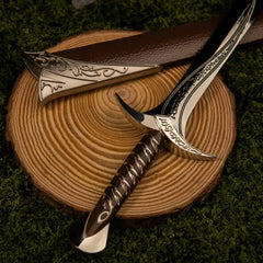 Sting replica — scrollwork crossguard and wrapped grip on a wood slice.