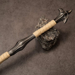 Fatalis Zaggespanon replica — cream-wrapped shaft with a dark swelled grip, resting on a stone.