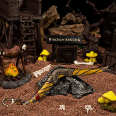 Boomerang replica (16.5cm die-cast zinc alloy) — laid across a stone in a handmade raiders'-camp diorama, by BlacksmithSONG.