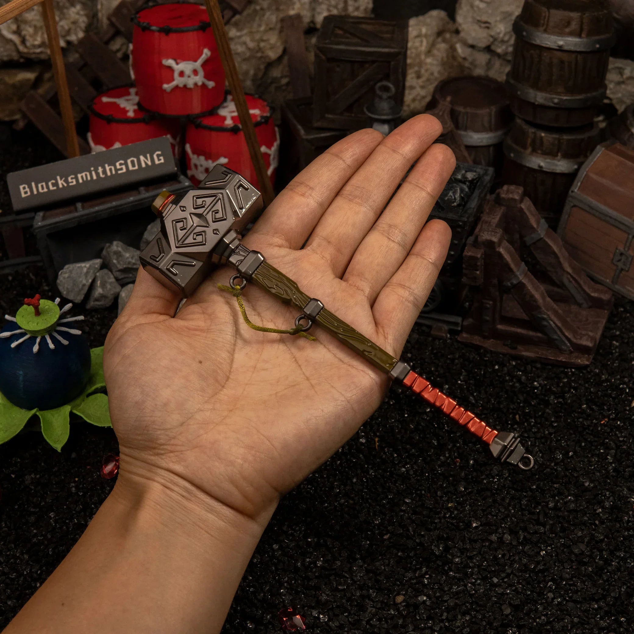 Human hand holding the 17.5cm Iron Sledgehammer replica, demonstrating its massive top-heavy head and 113g weight.