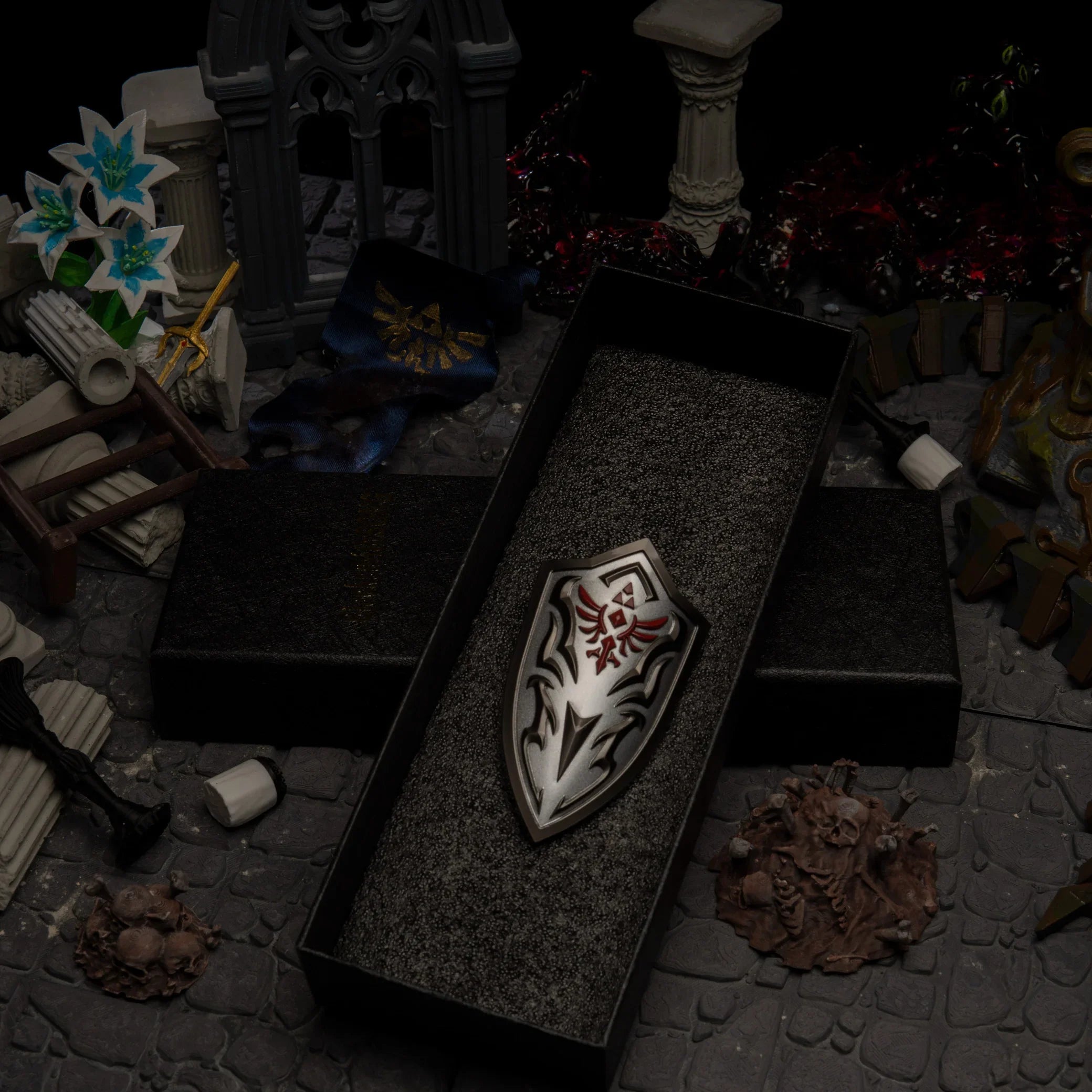 1/6 scale Royal Guard's Shield metal miniature inside a black gift box, surrounded by a ruined castle diorama.