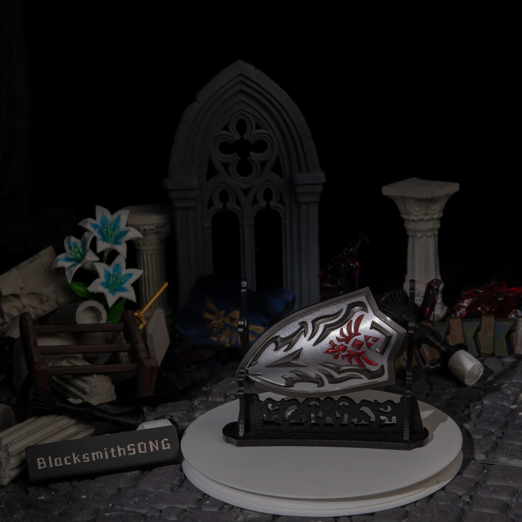 Royal Guard's Shield metal replica showcased on a large horizontal wooden stand (sold separately) in a ruined castle setting.