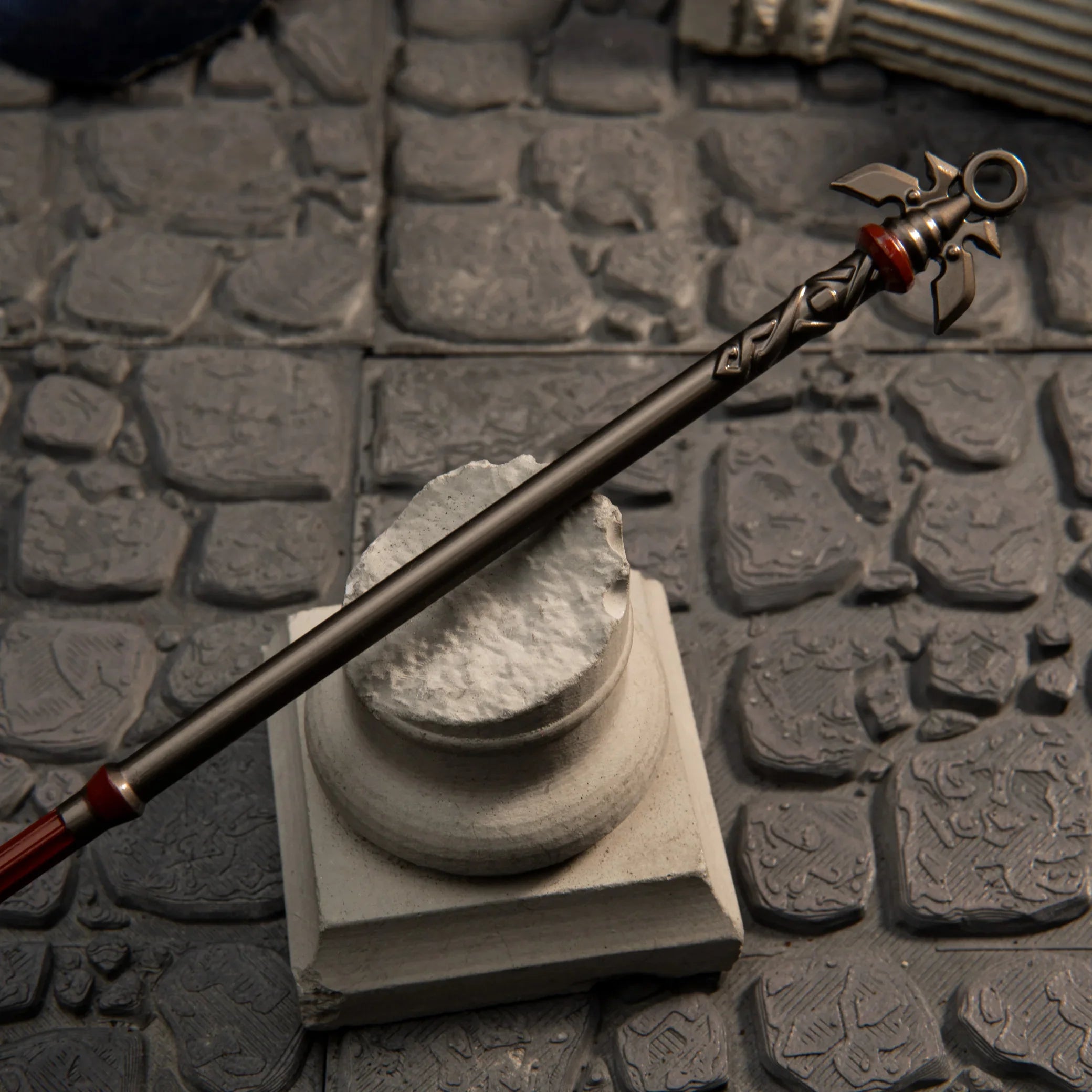 Detailed view of the dark zinc alloy shaft and red string on the Royal Guard's Spear replica.