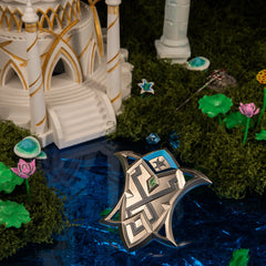 Silver Shield replica (9cm die-cast zinc alloy shield) — resting in the coral court set, by BlacksmithSONG.