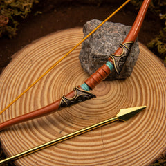 Traveler's Bow replica — carved tip and grip wrap detail, cast arrow laid alongside for scale.